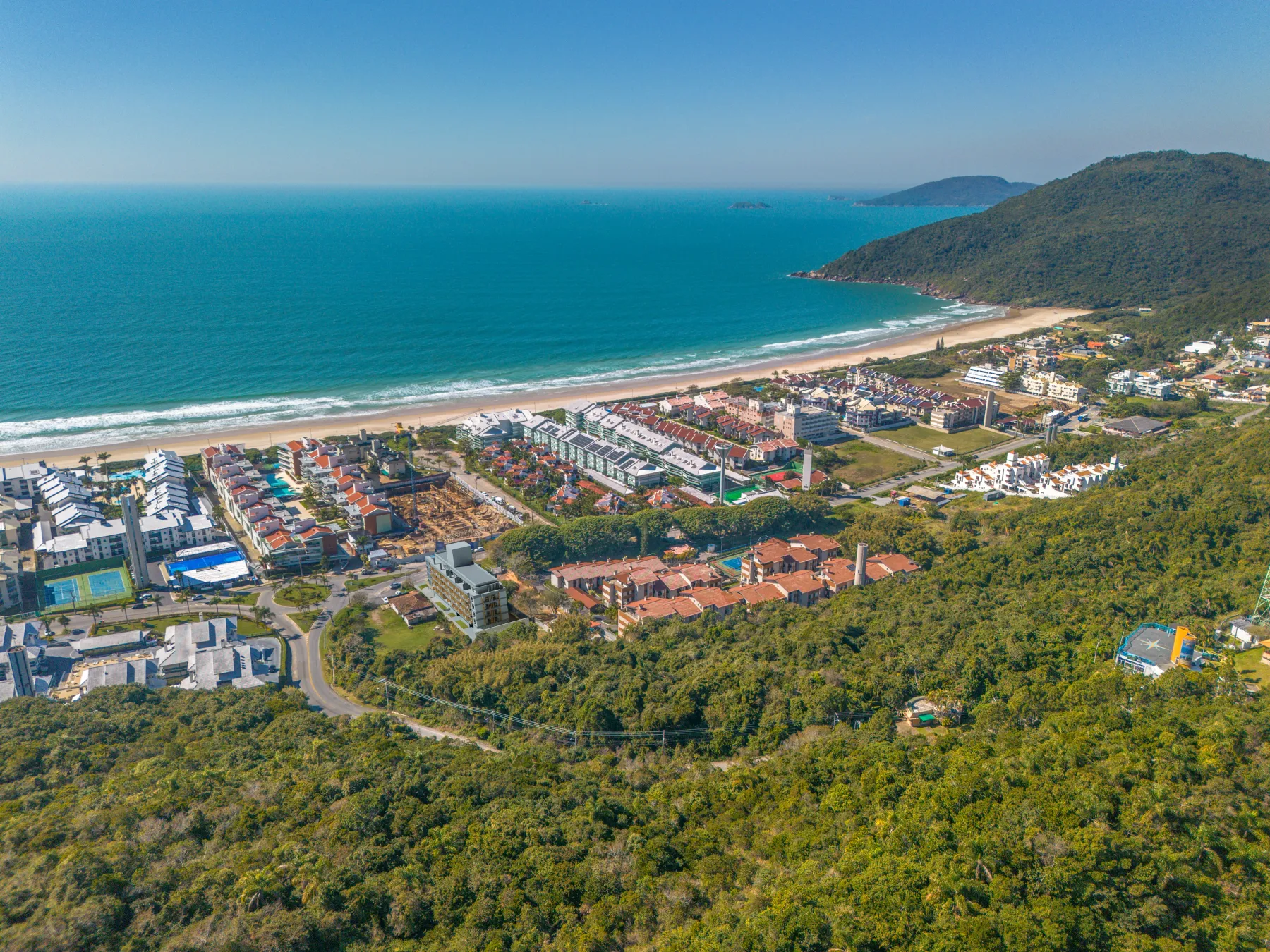 Vista aérea real da Praia Brava — mar azul e natureza preservada